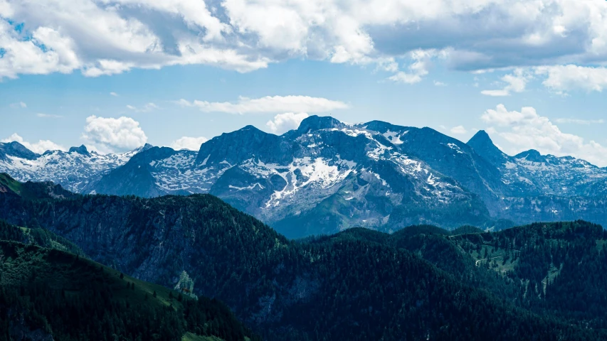 a large mountain range with trees in the foreground