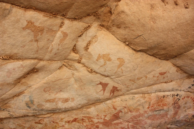 a stone wall with pictures painted on it