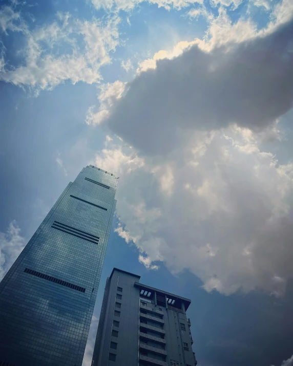 the sky is really cloudy over two tall buildings