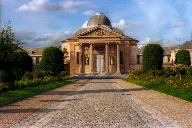 a building with a dome is shown on a dirt path