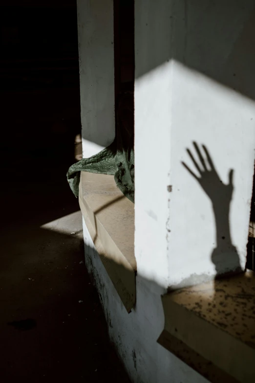 the shadow of a hand casting a shadow on a wall