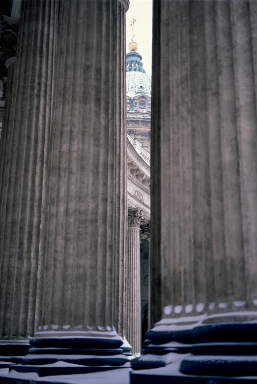 two pillars are surrounded by snow in front of an old building