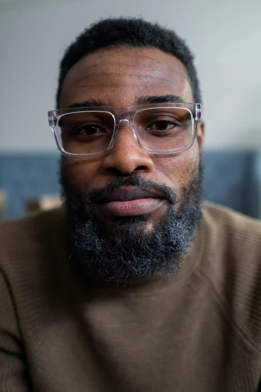 a man with glasses, mustache and beard wearing a sweater