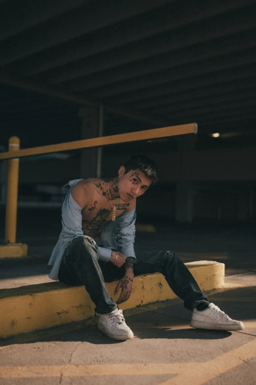 a boy sitting on the ground with his foot on a railing