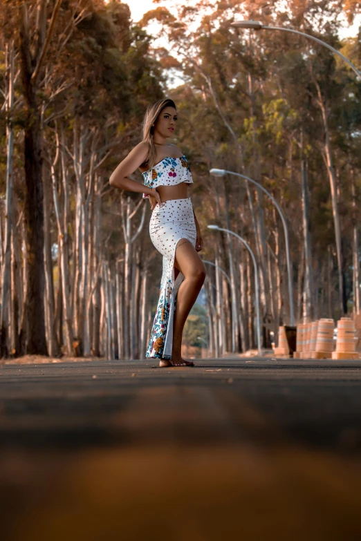 the woman is posing in a white dress