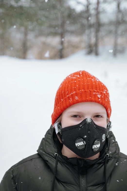 a person wearing a face mask while standing in the snow