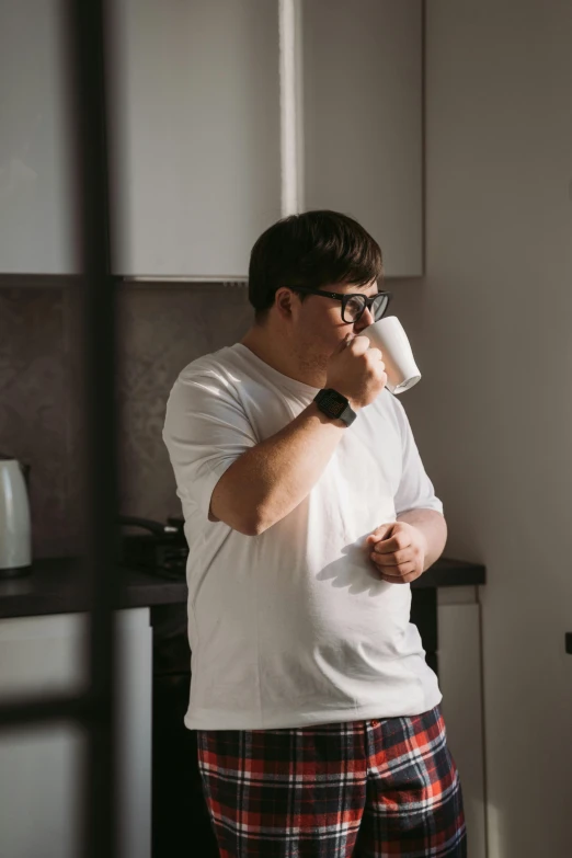 a man drinking a drink in pajamas