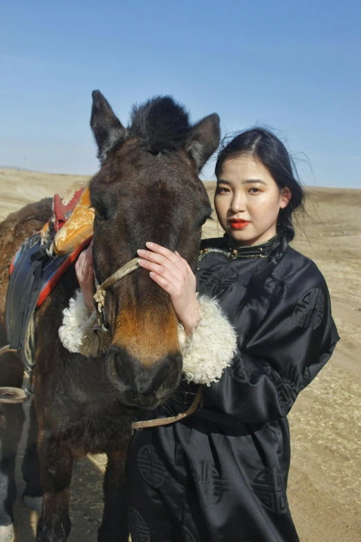 the woman is standing next to her horse