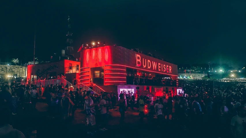 a large crowd is gathered in front of a red building