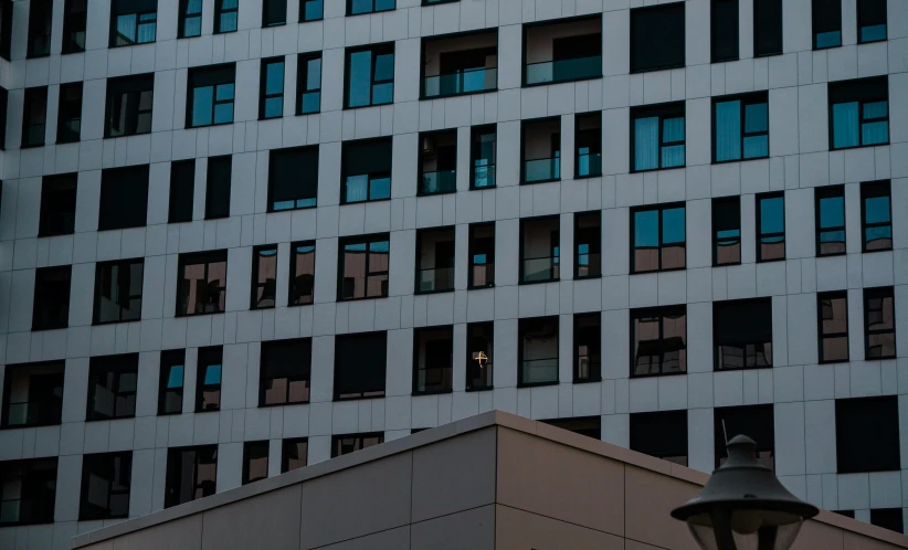 a tall building next to some buildings with lots of windows