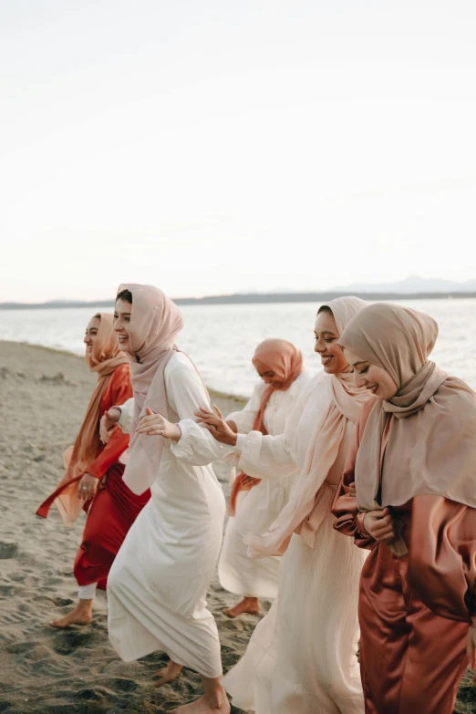 a group of women walking on the beach