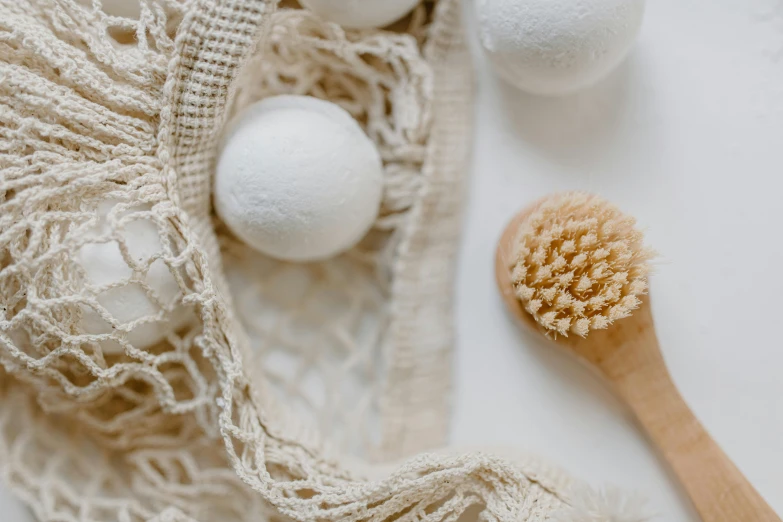 two bath brushes sitting on top of the lace covered table cloth