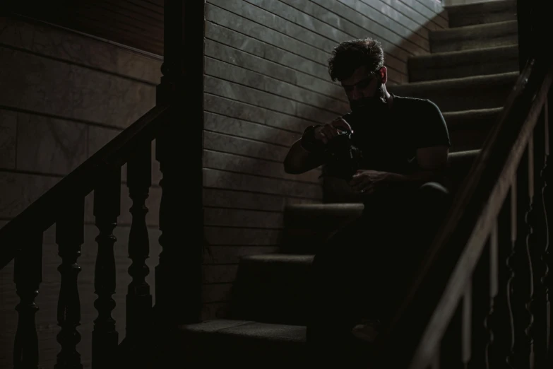 a man sits on the stairs with his phone