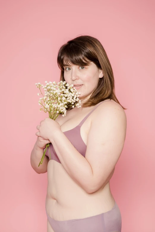 a women who is wearing a  holding a bunch of flowers