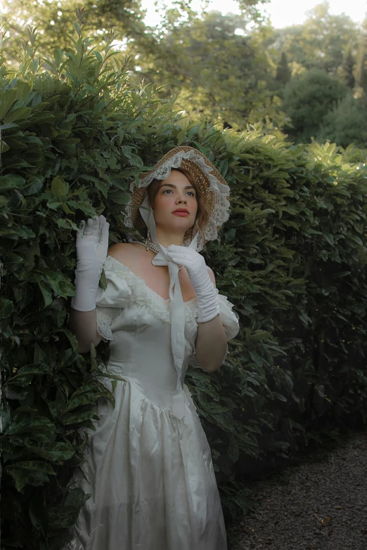a young woman wearing a wedding gown and gloves