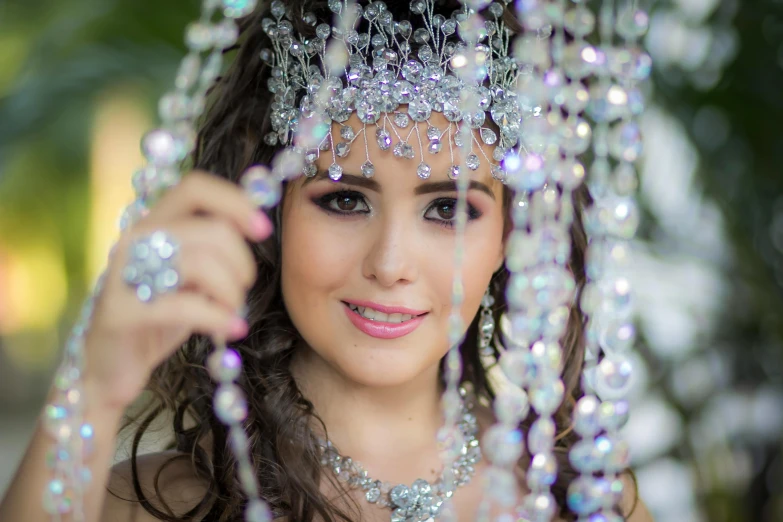 a woman in an oriental dress holds a beads head piece