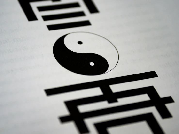 there is a yin and letter logo in black and white