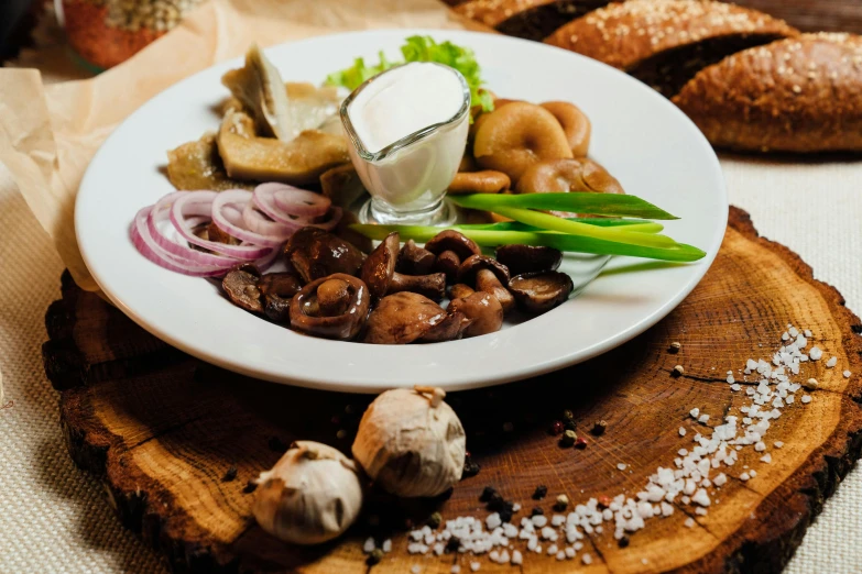 a white plate filled with meat covered in mushrooms and sauce