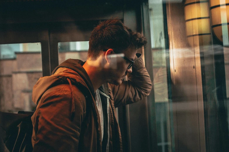 a man with glasses walking while using his cellphone