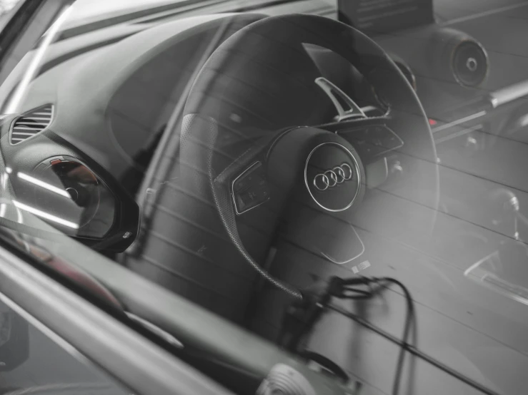 a steering wheel of a car seen through the front window