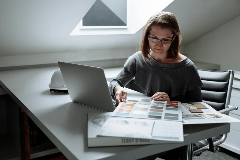 woman in an office setting reading on her laptop