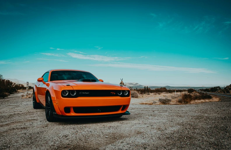 an orange car is parked in the desert