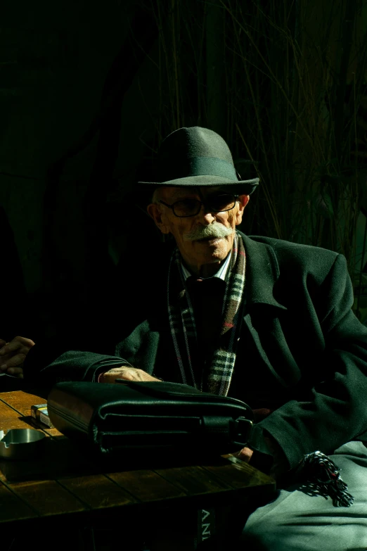 a man is sitting at a table with his suitcase in hand