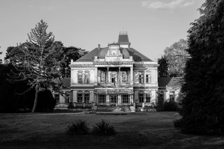 an old house with lots of plants and trees around it