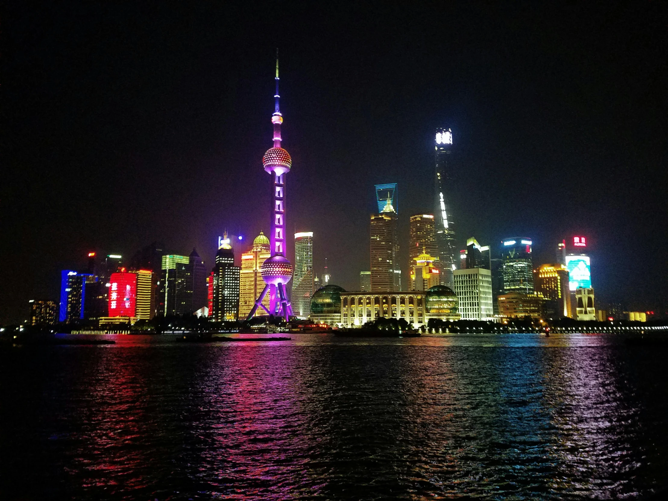 brightly lit buildings reflected in the water at night