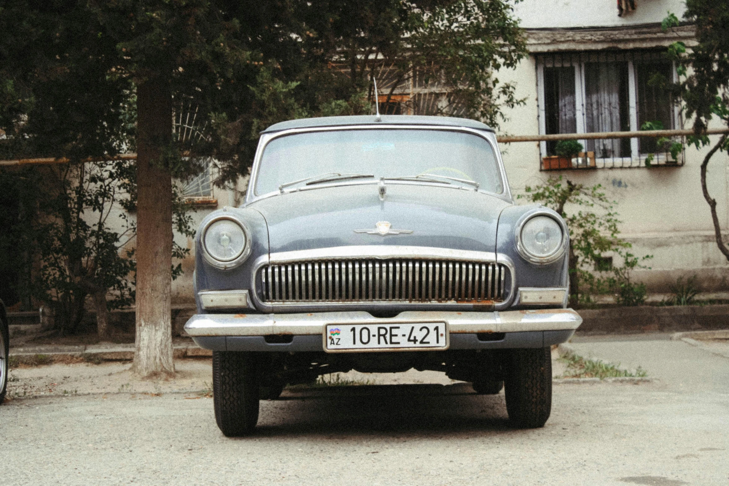 a close up of an old car on the side of a street