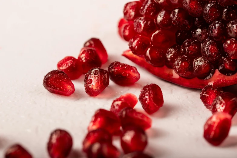 a bunch of red fruits on white table