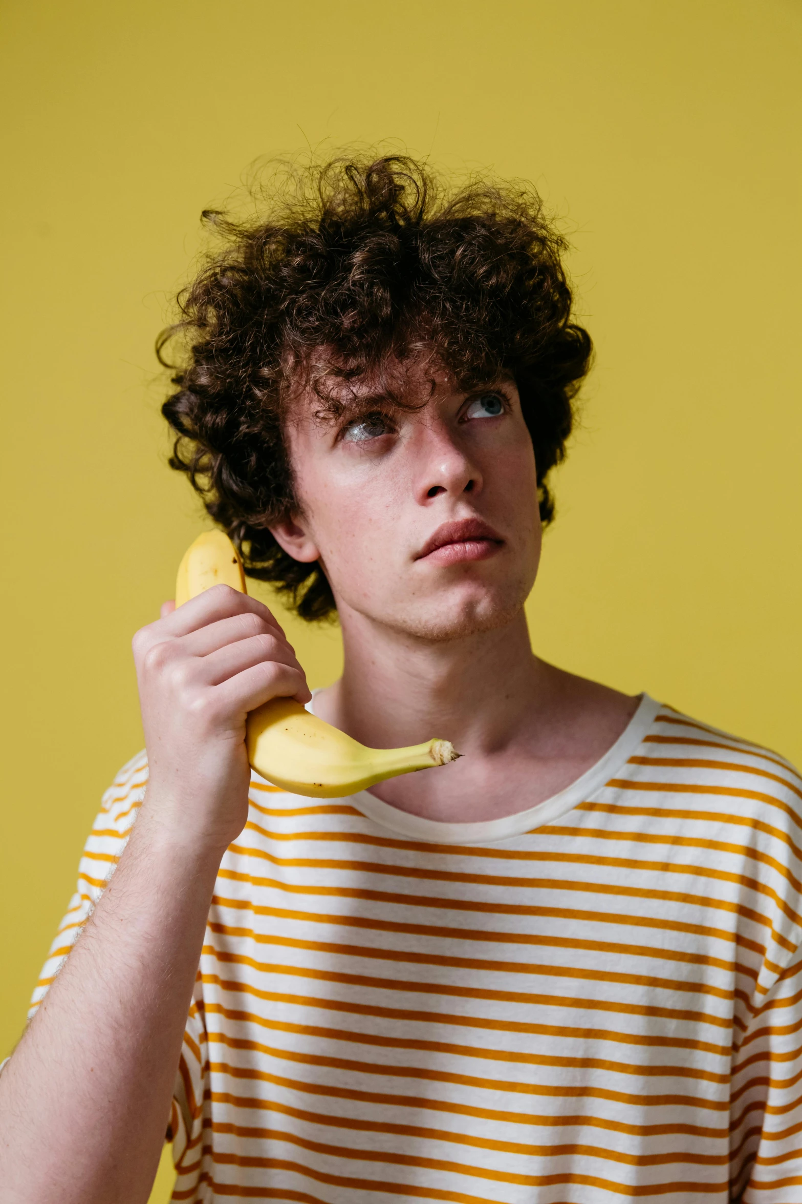 a boy holding a banana to his face