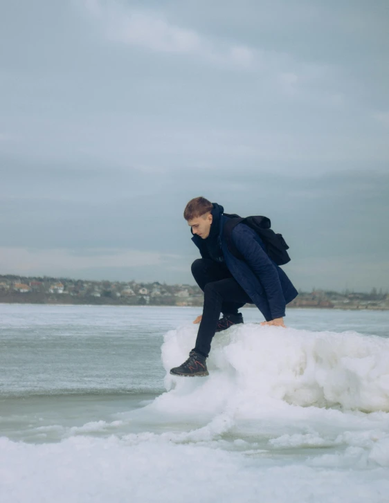a man standing on ice and water with his foot in the air