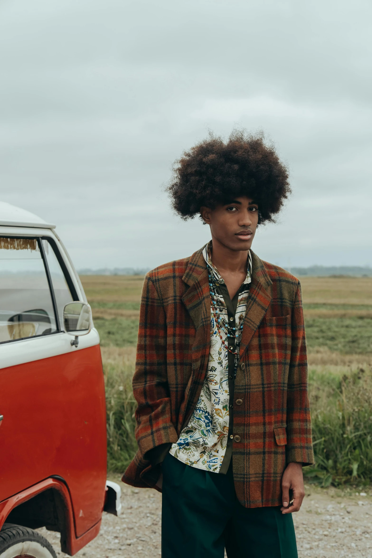 an african american man posing in front of a van