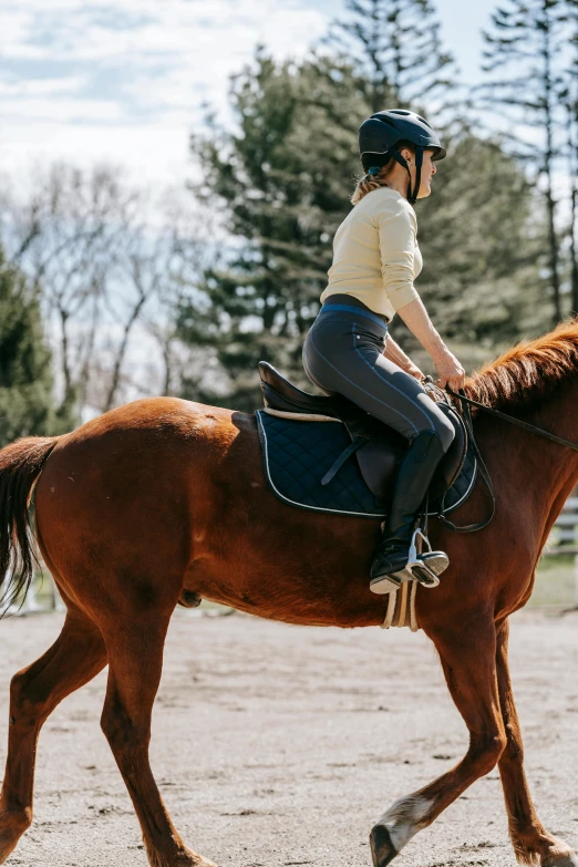 woman riding on top of a horse outside