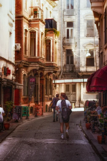 two men walk down an old city street