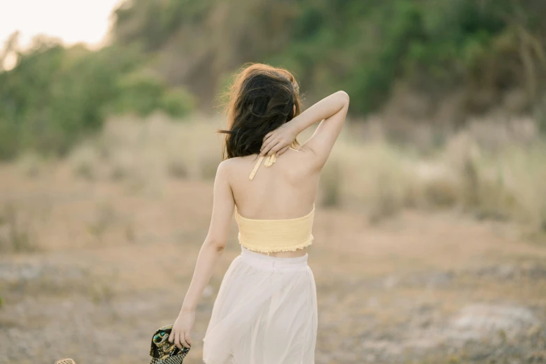 the back of a woman walking in a grassy field