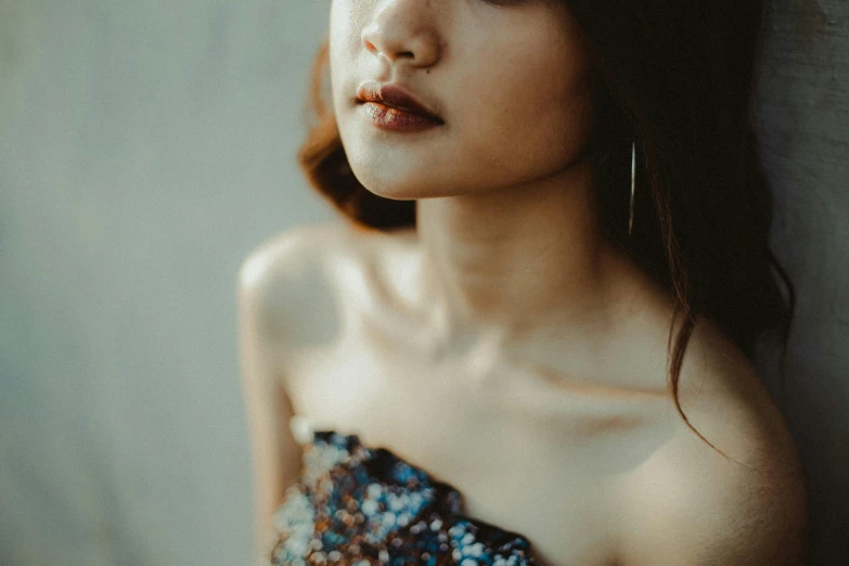 a beautiful young woman leaning against a wall