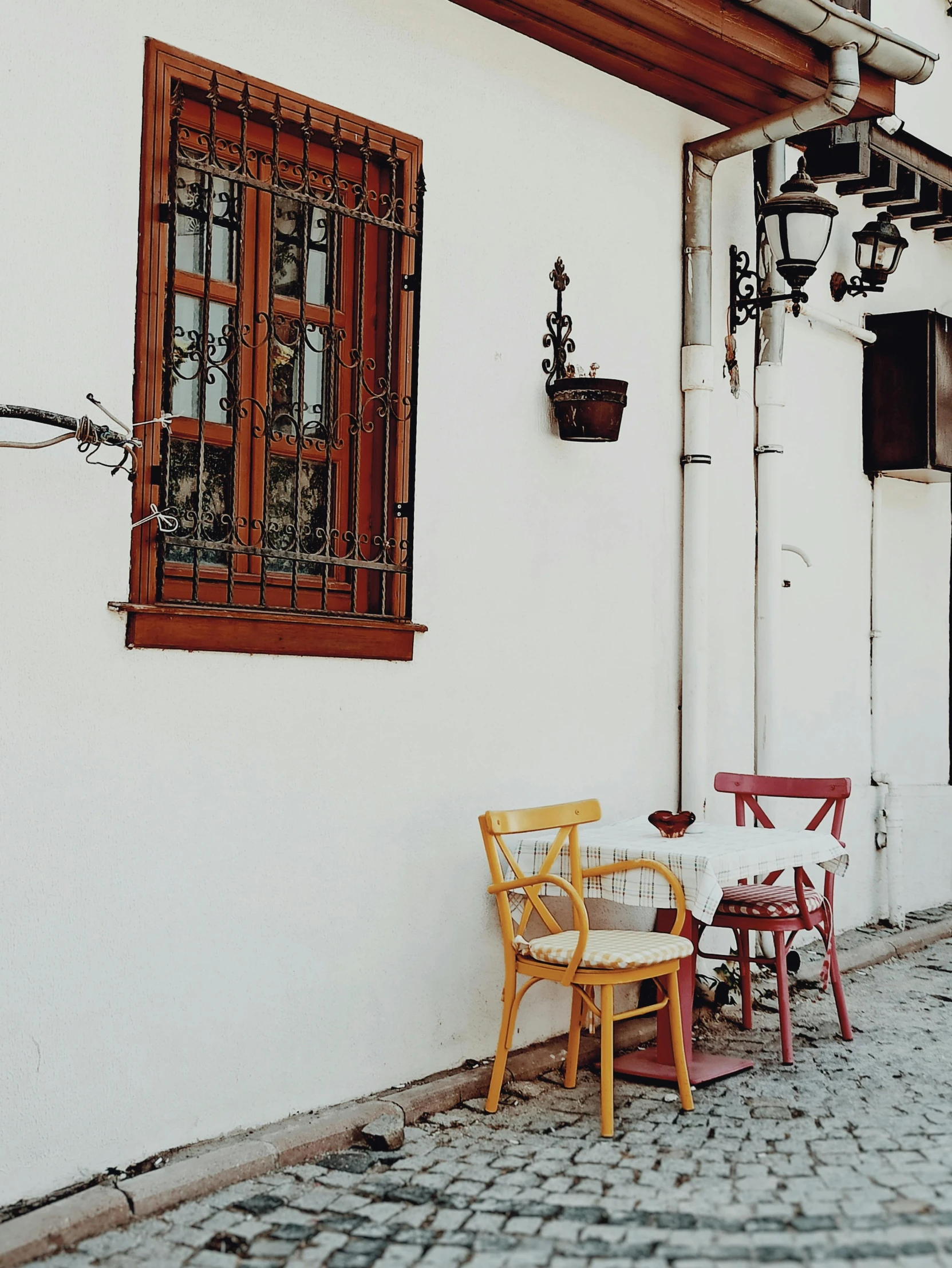 the tables are set and the chairs are up against a white building