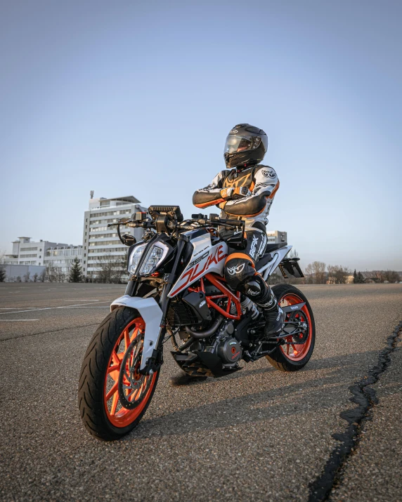 a man on a silver and orange motorcycle rides it