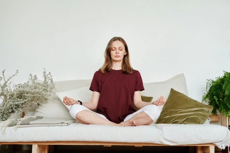 a woman is sitting on a couch with many pillows