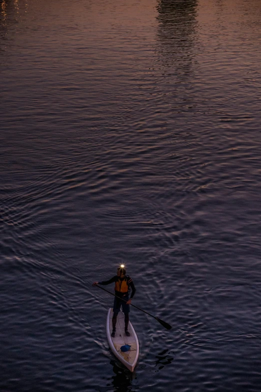 a man stands on a paddle board in the water