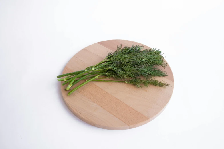 a wooden board holding some chopped up green vegetables