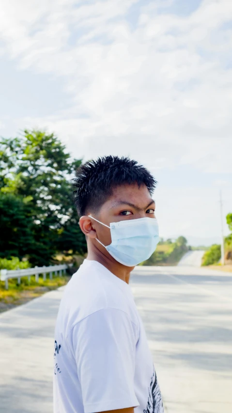 a man standing on a street wearing a mask