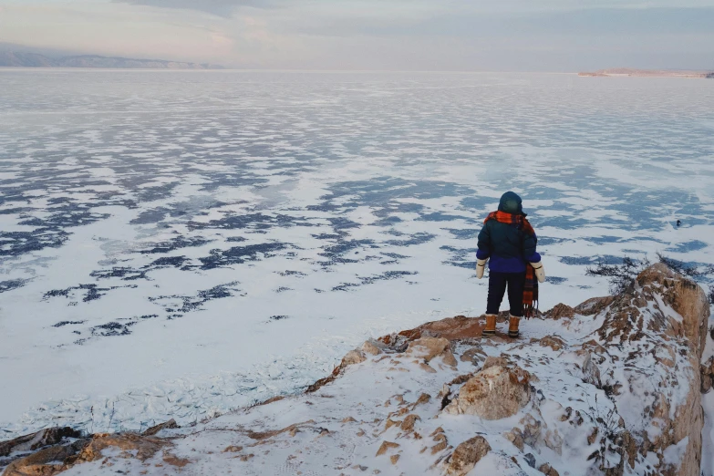 a man standing on the edge of a large lake