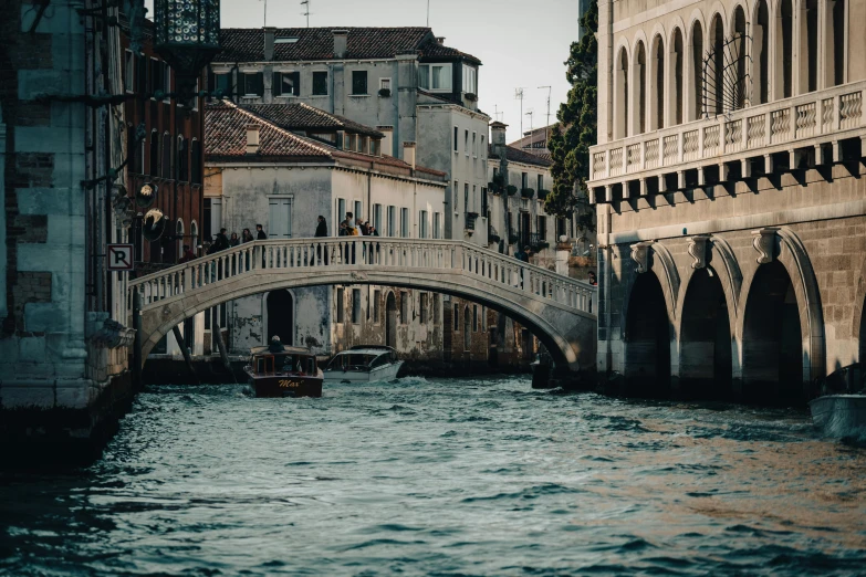 an old bridge crosses the canal near some buildings