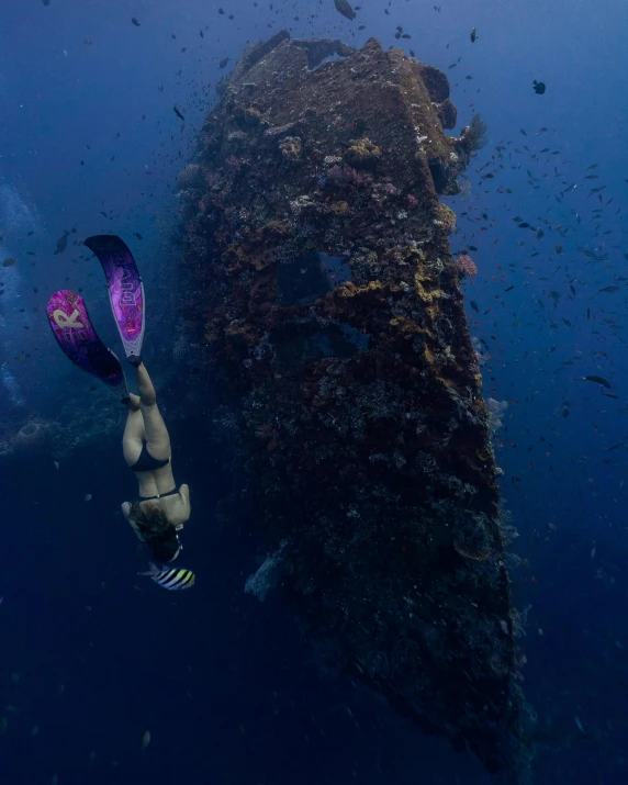 a man swimming next to a huge ship