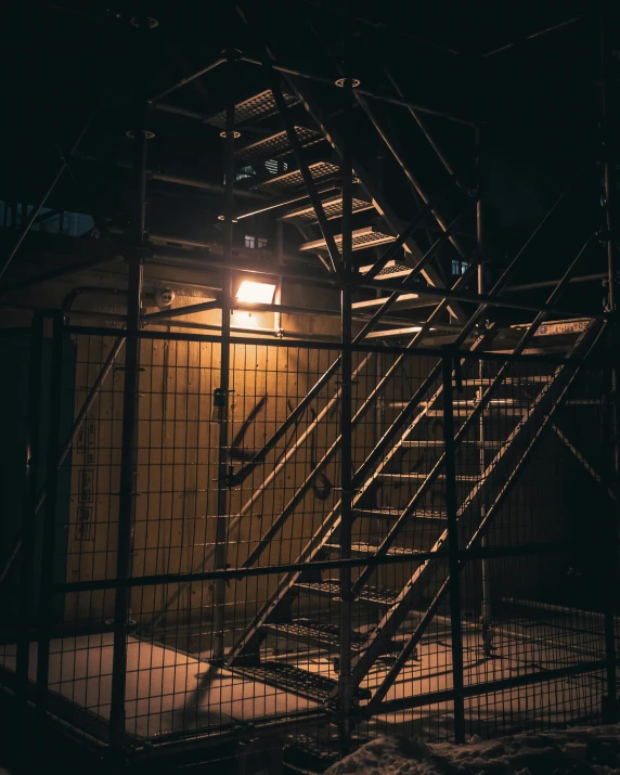 a fire escape with stairs and lights is dimly lit