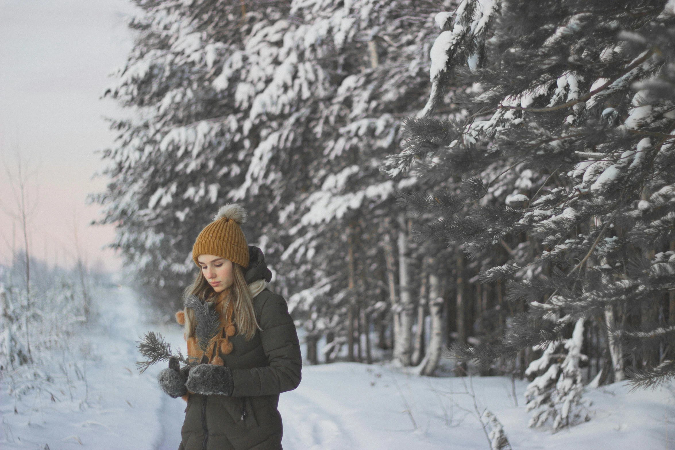 the woman is standing in the snow holding her hands together