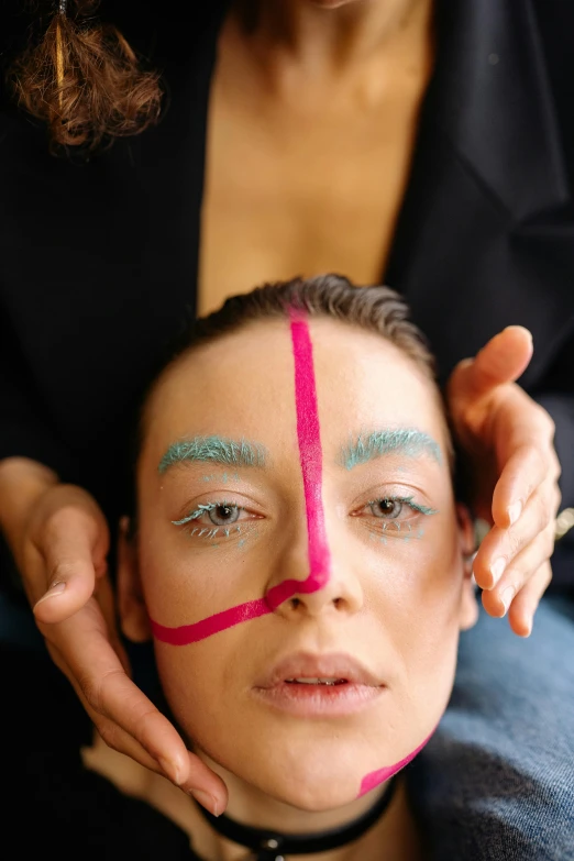 a woman in pink is being colored with a bright pink tape